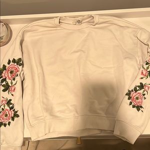 white crew neck with flower detailing on sleeves